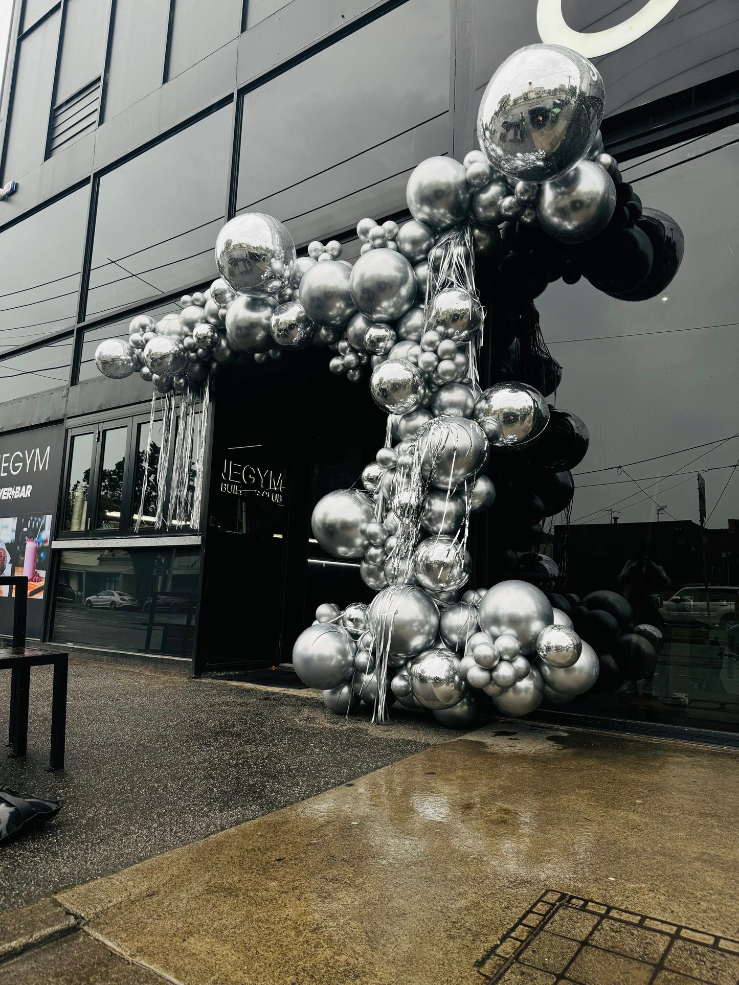 Decorative sculpture made of reflective silver spheres in front of a building at One Gym Port Melbourne.