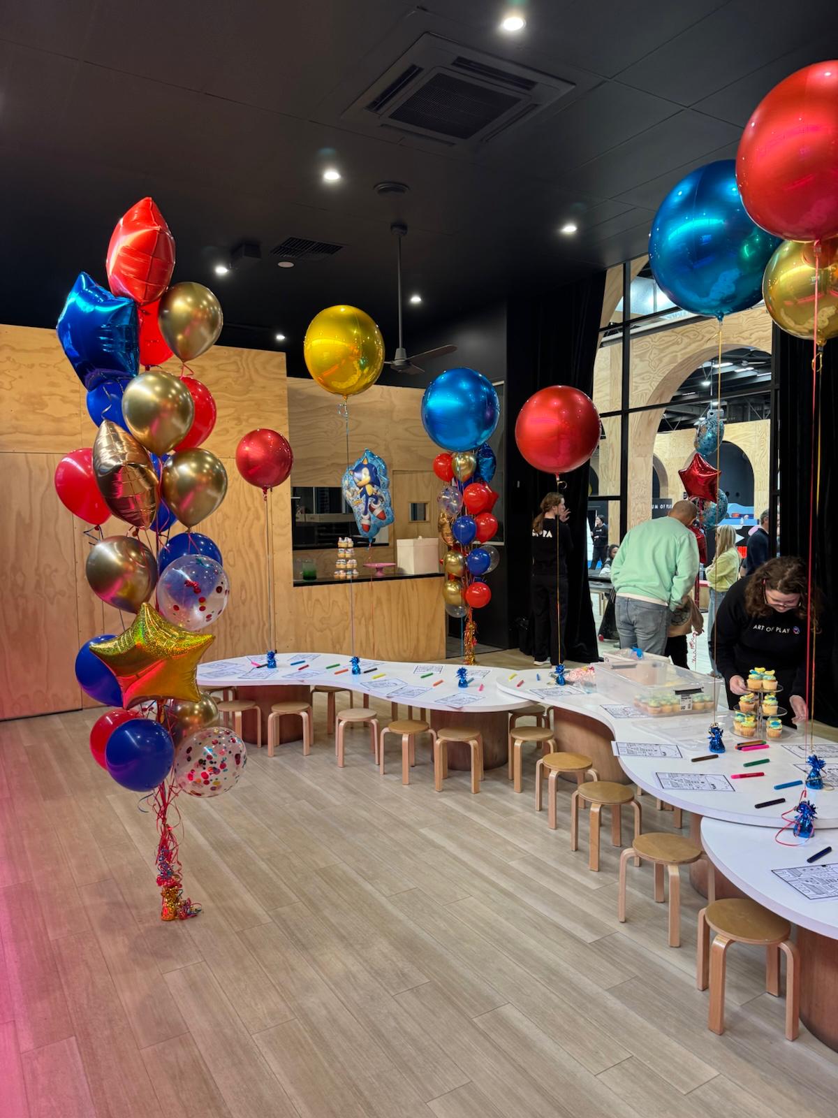 Decorated room with colorful balloons and tables set up for an event at MOPA Sandringham by Fairytale Balloons 
