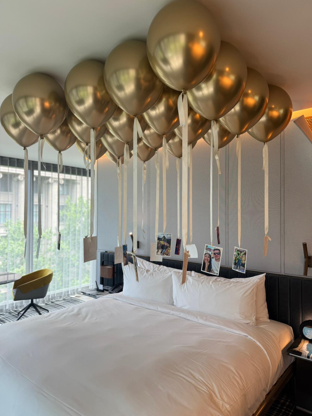Free flowing gold balloons helium on a hotel ceiling with romantic photographs in Melbourne CBD