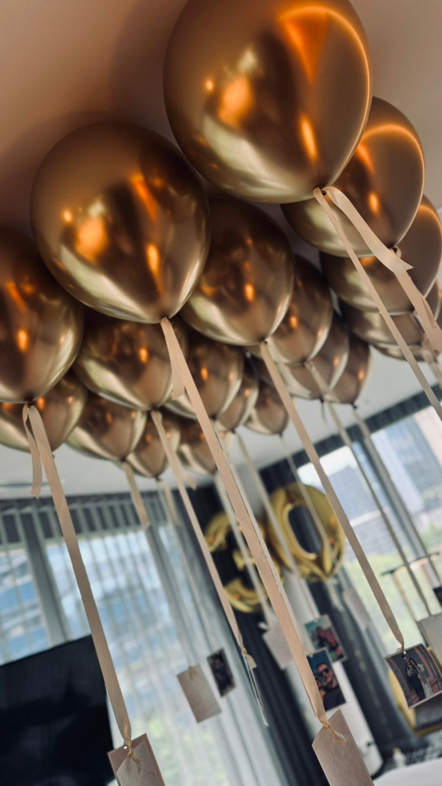 Free flowing gold balloons helium on a hotel ceiling with romantic photographs in Melbourne CBD
