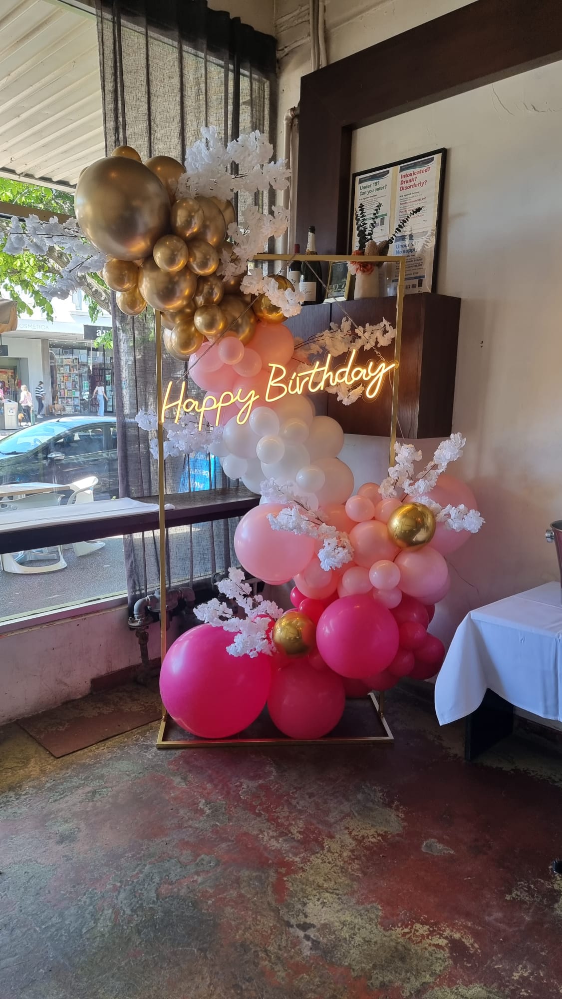 Pink Garland with White Faux Flowers and a "Happy Birthday" Neon