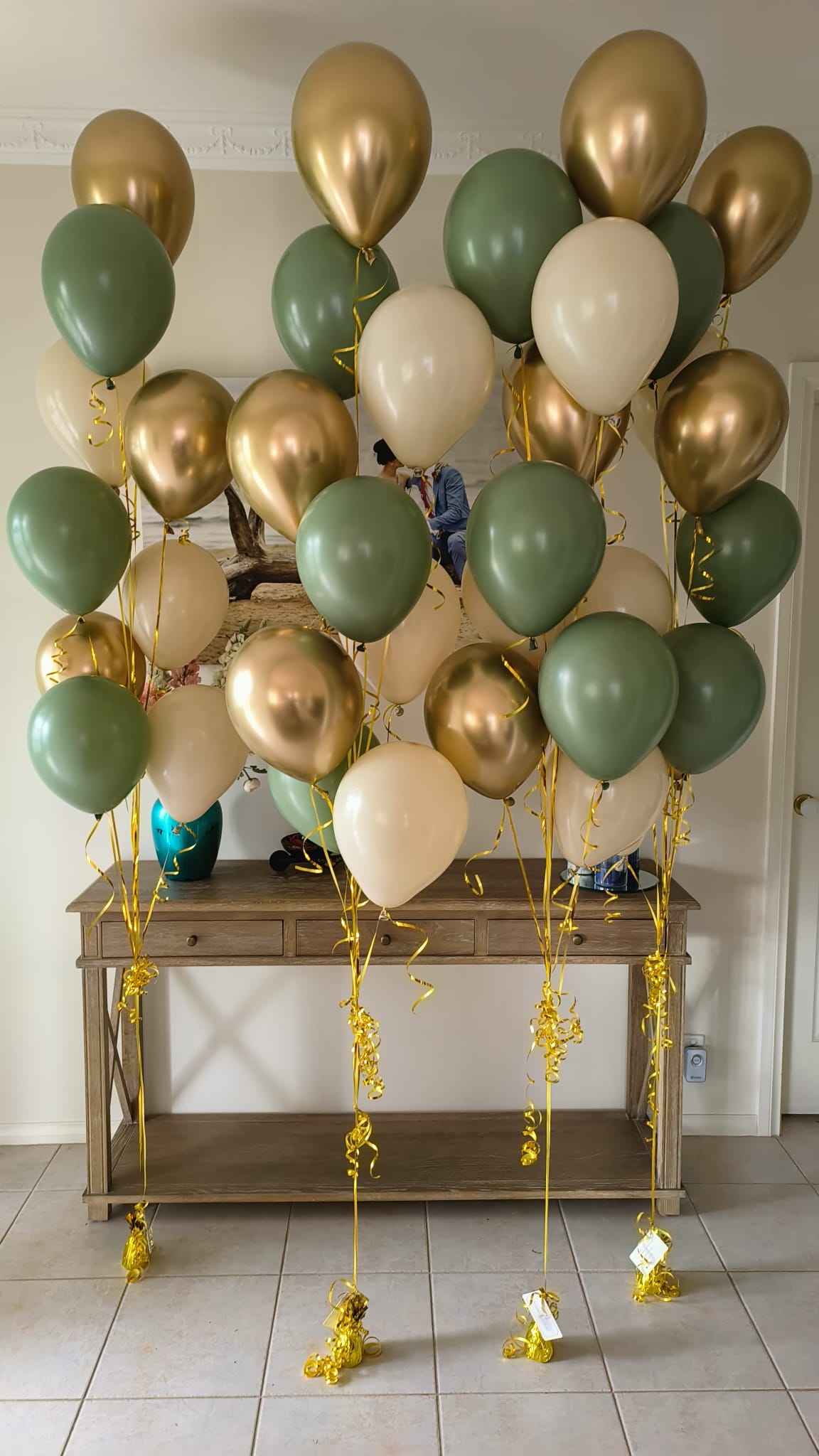 2 Gold Hazel and White Sand Balloon Bouquets before a table and vases in Melbourne waiting for Delivery