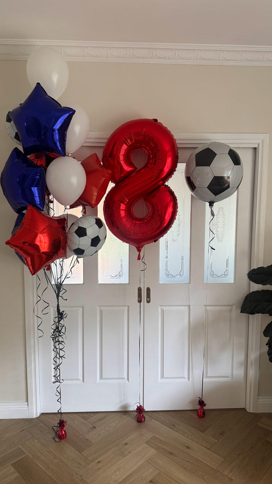 Decorative balloons with numbers and sports-themed designs on a wooden floor.