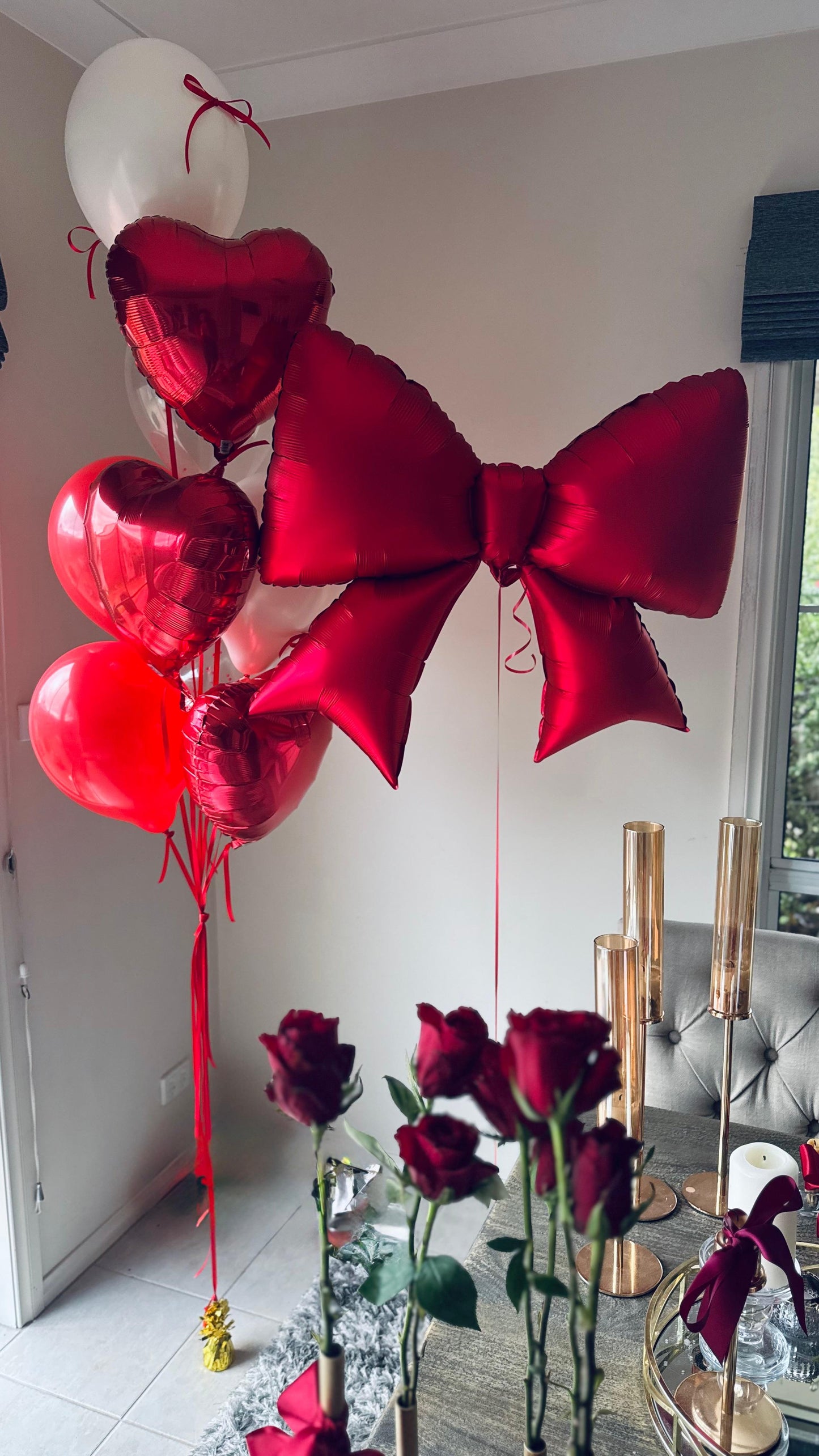 Decorative balloons with red ribbons and flowers on a table for a party in Melbourne 